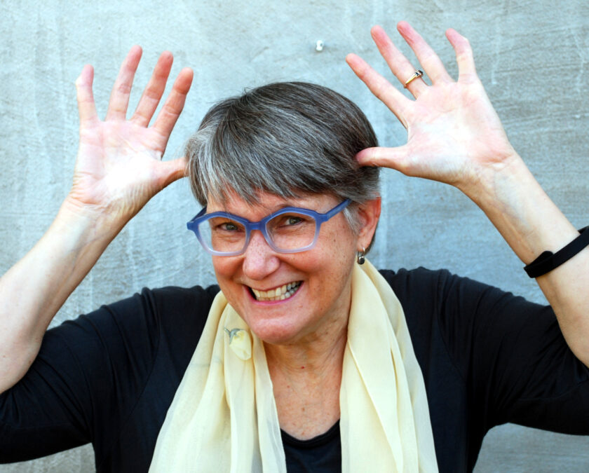 Smiling woman making jazz hands on the sides of her head